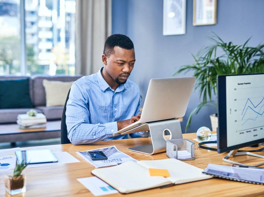 South African business owner reviewing social media marketing costs and strategy on a laptop.