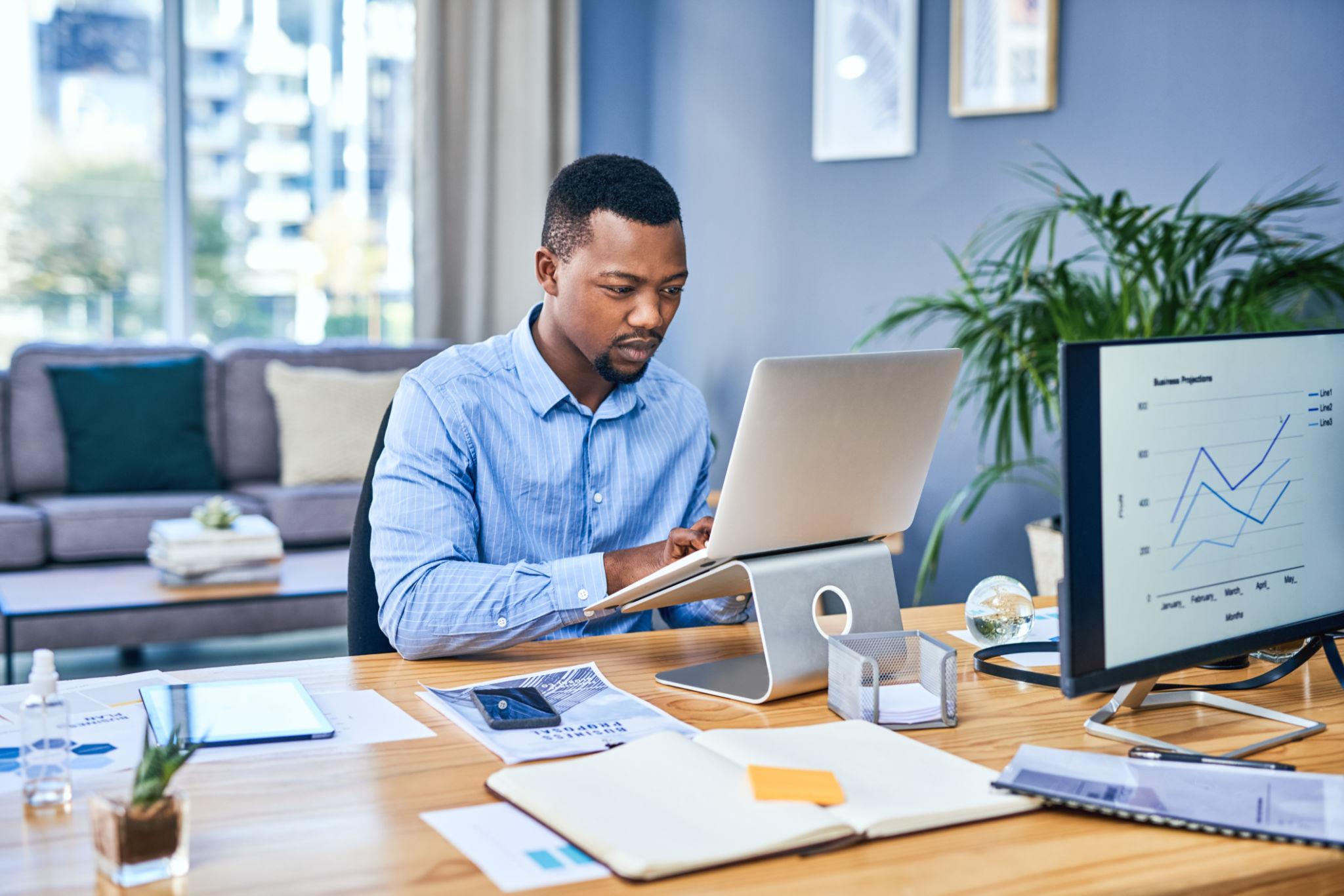 South African business owner reviewing social media marketing costs and strategy on a laptop.